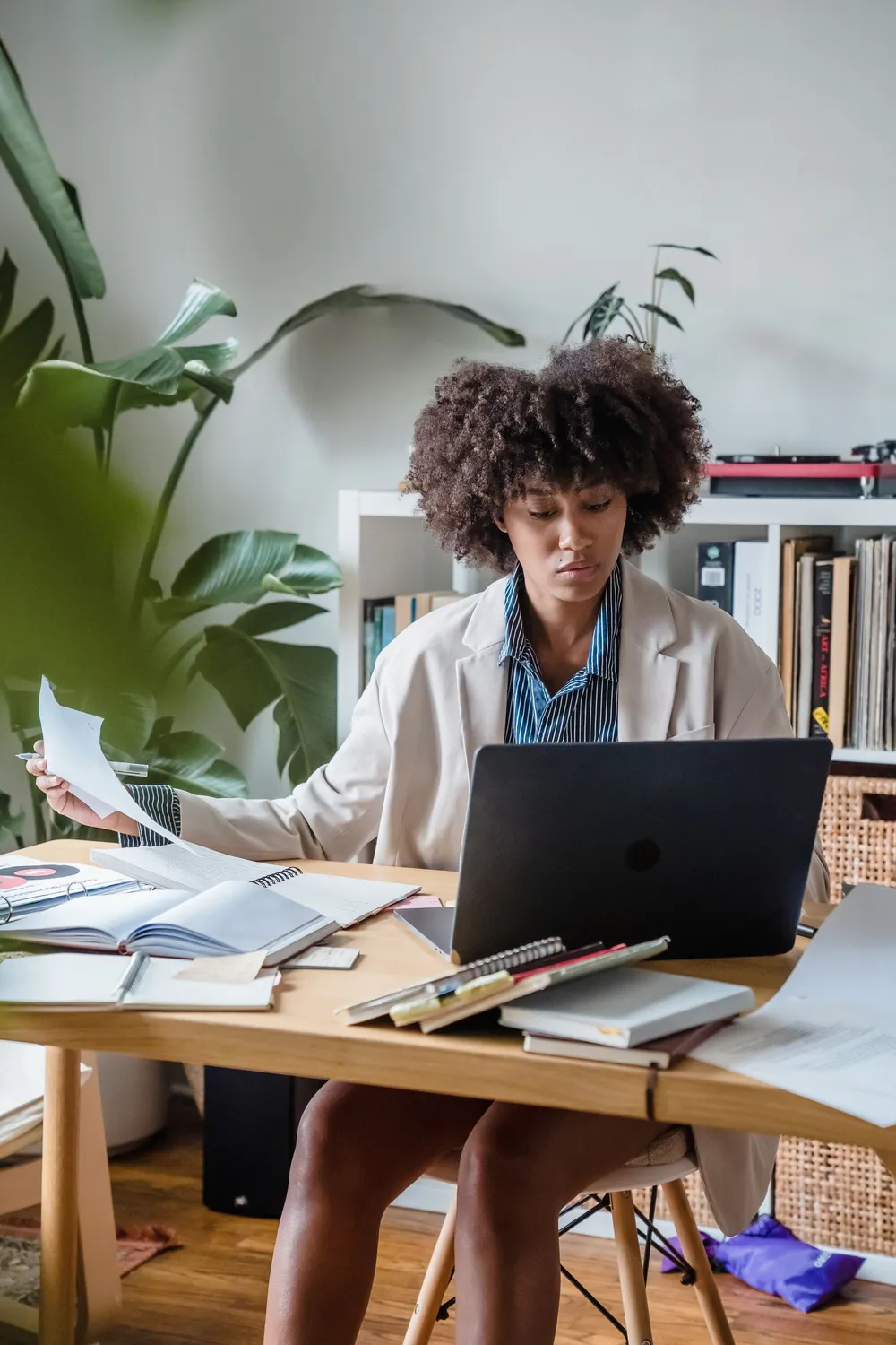 Un indépendant consulte son téléphone, ses papiers posés sur le bureau.