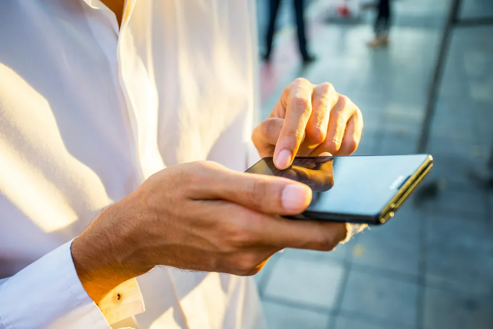 Une personne partage un lien de paiement depuis son téléphone.